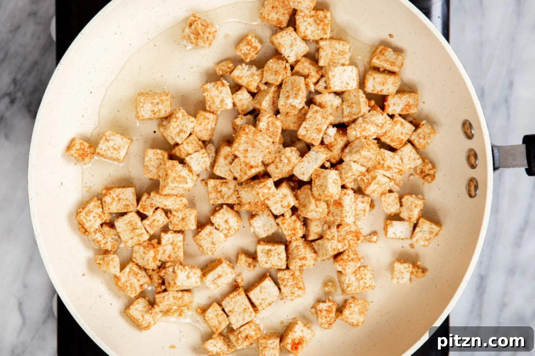 Vegan Tofu Matar 9 marinated cubes of tofu frying in a pan
