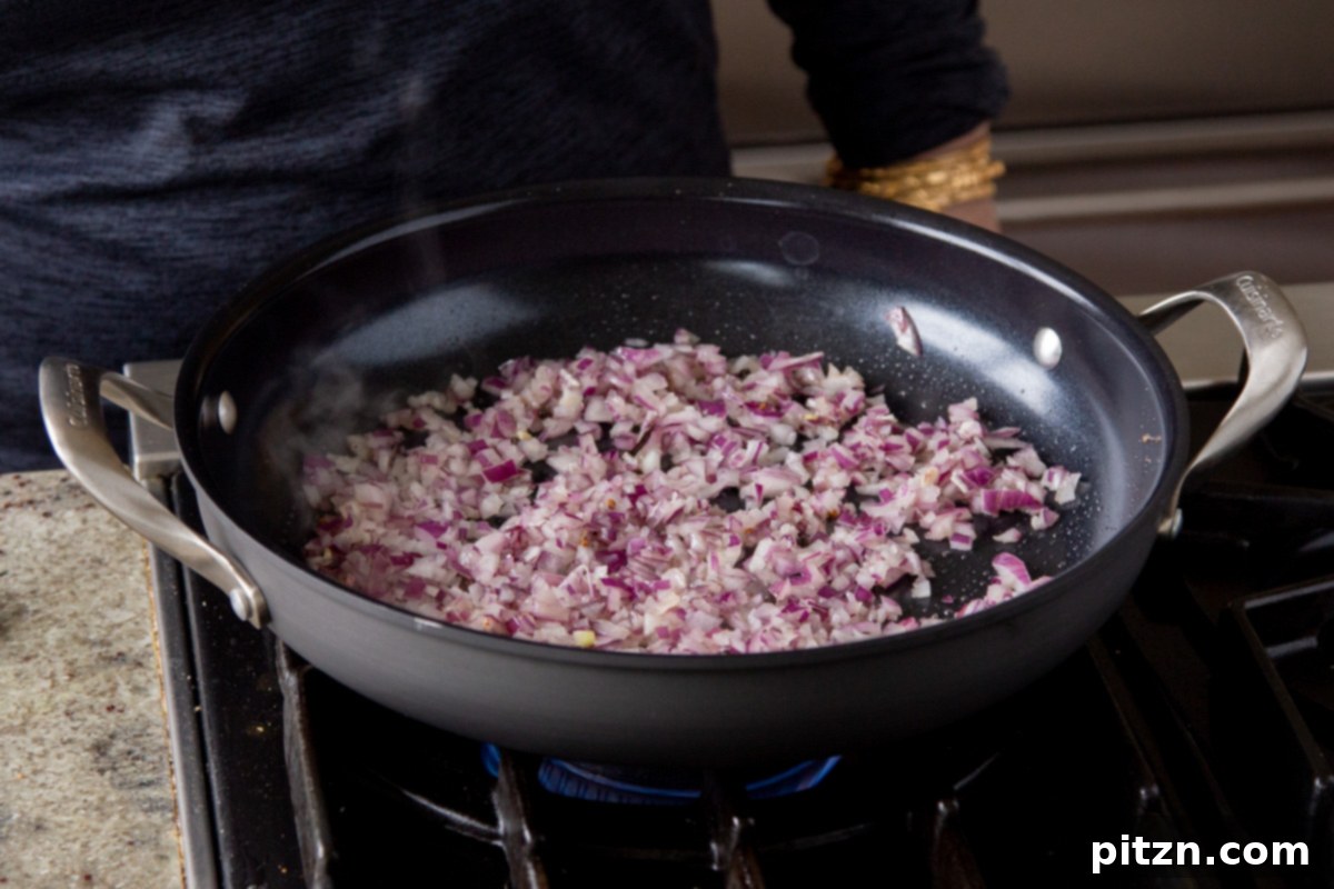 Creamy Fenugreek Tofu and Chickpea Curry 14 Adding finely chopped red onions to the pan with tempered spices and vegan butter
