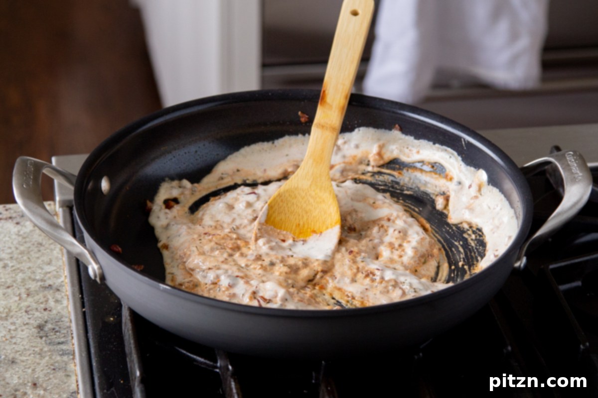 Creamy Fenugreek Tofu and Chickpea Curry 17 Vegan cashew cream mixed smoothly with spices and onions in the pan, forming a creamy sauce
