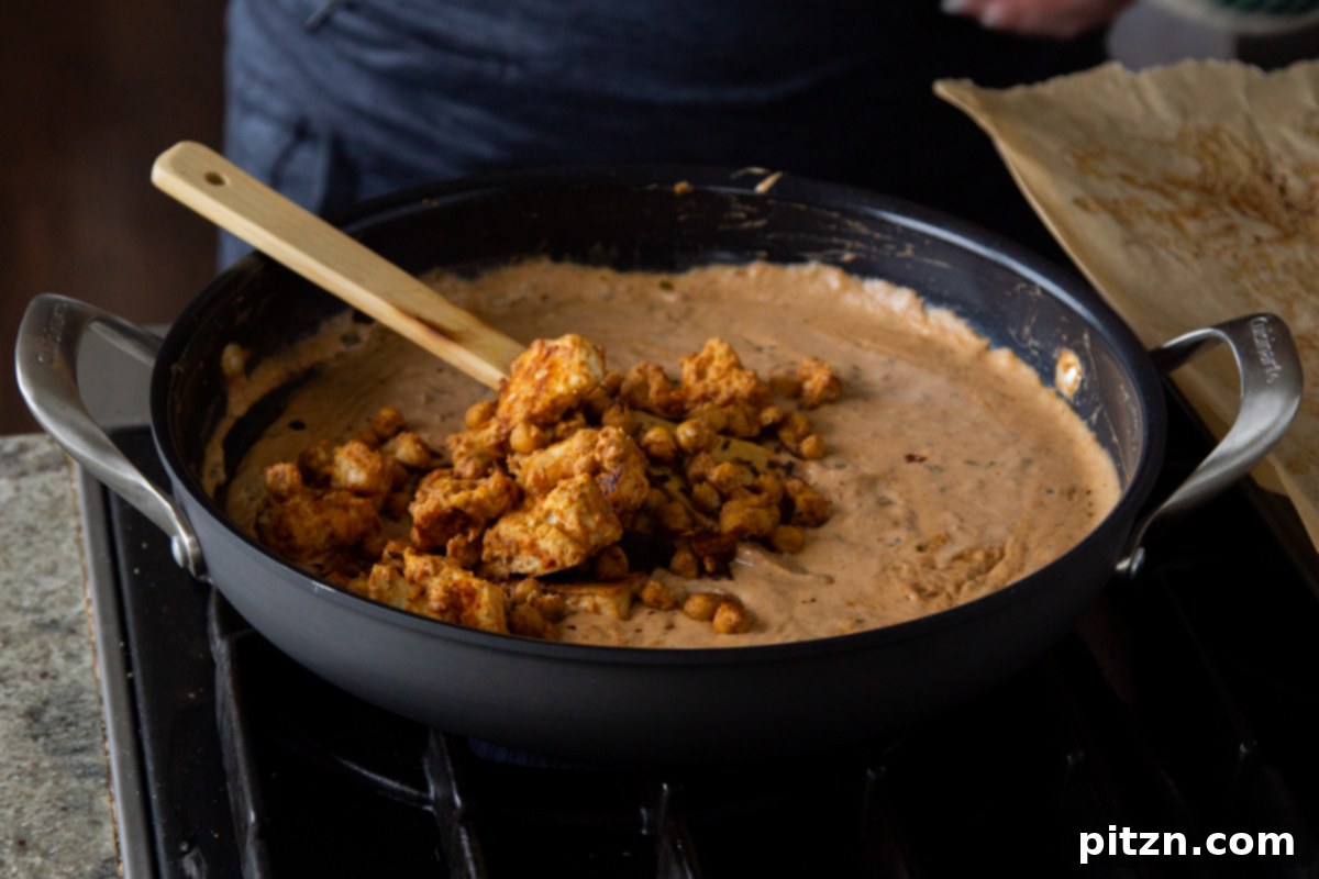 Creamy Fenugreek Tofu and Chickpea Curry 20 Adding the baked tofu and chickpeas to the cooked creamy curry sauce in the pan