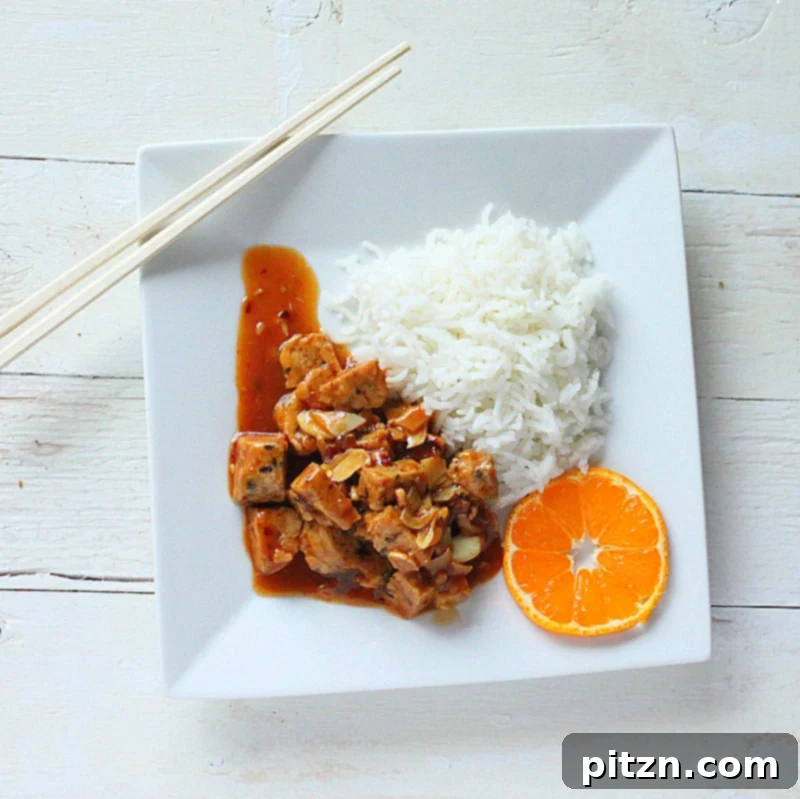 Close-up of cubed tempeh simmering in a flavorful sauce