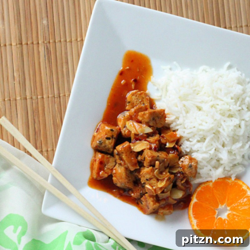 General Tso's Tempeh with vibrant orange slices and green onions garnish