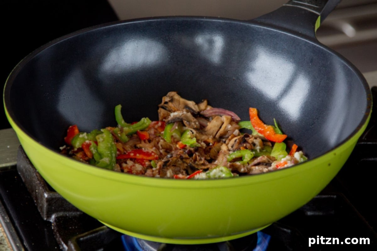 Decadent Vegan Butter Chicken Ramen 15 Sautéed bell peppers, mushrooms, and onions in the wok, after cooking with ginger-garlic paste.