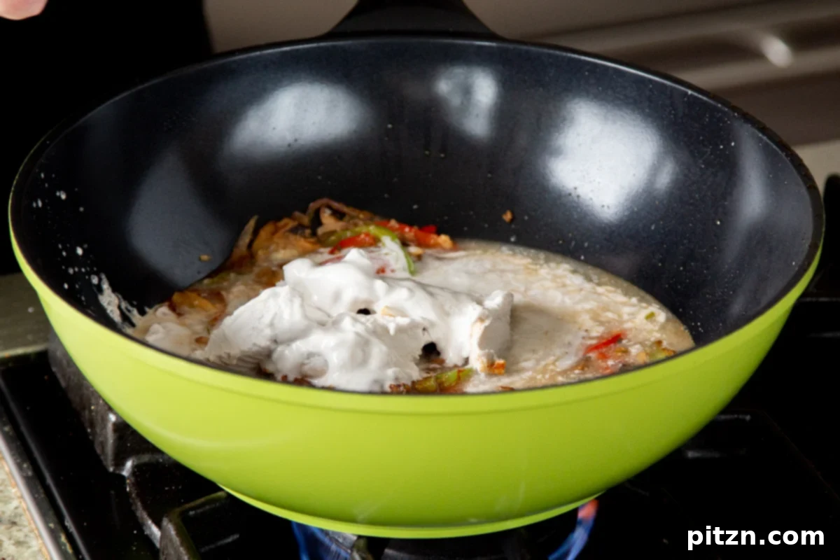Decadent Vegan Butter Chicken Ramen 17 Pouring full-fat coconut milk into the wok with the seasoned vegetables and spices.
