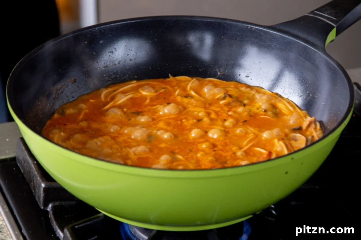 Decadent Vegan Butter Chicken Ramen 19 Vegan Butter Chicken Ramen simmering in the wok, with noodles absorbing the rich, creamy broth.