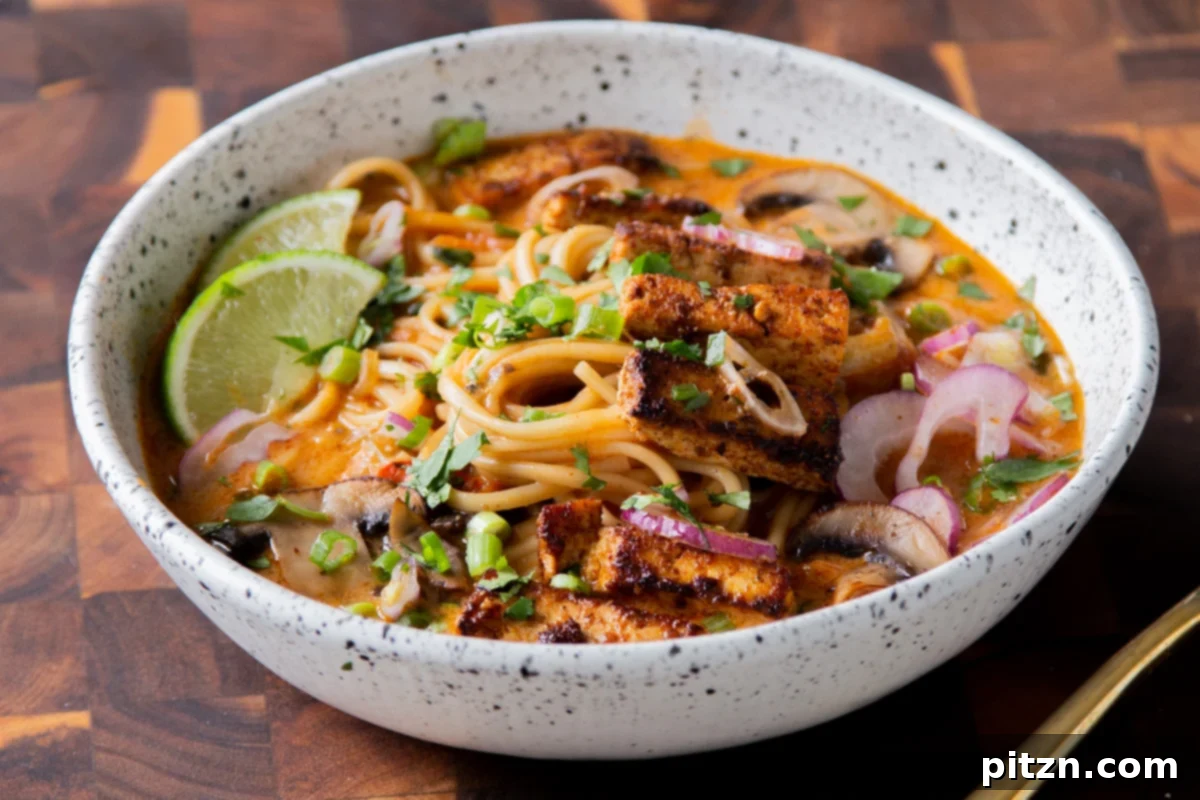 Decadent Vegan Butter Chicken Ramen 21 A beautifully plated bowl of Vegan Butter Chicken Ramen with crispy tofu and a lime wedge, ready to be enjoyed.