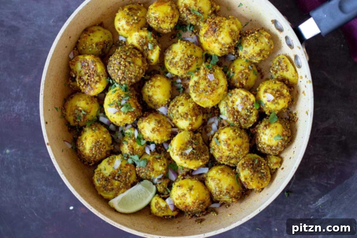 Finished peanut sesame potatoes served in a bowl, exquisitely garnished with fresh cilantro and vibrant red onion.