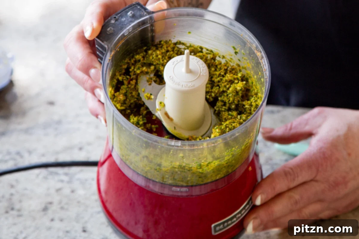 The finely ground mixture of peanuts, sesame seeds, and spices in the food processor after blending.