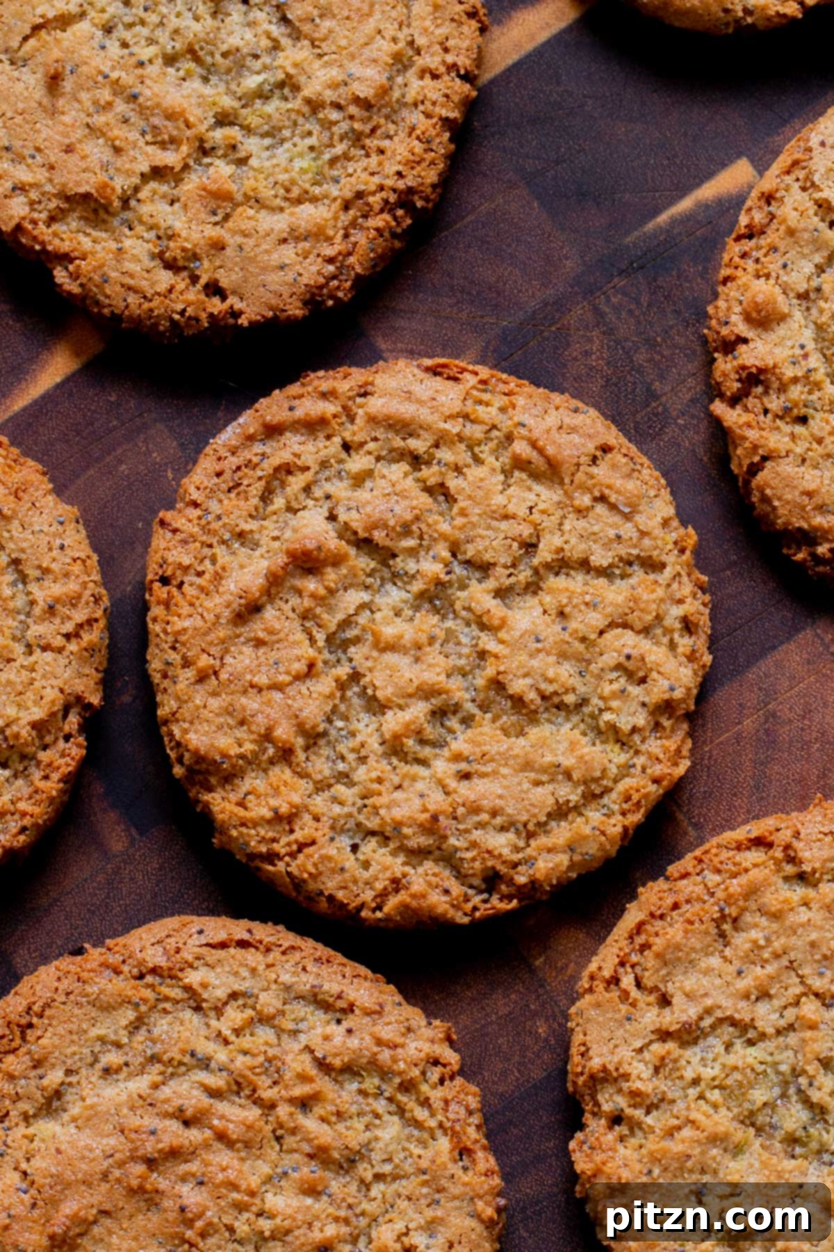 Delicious vegan lemon poppyseed cookies artfully arranged on a rustic wooden table, highlighting their inviting golden hue and chewy texture. Perfect for a gluten-free treat.
