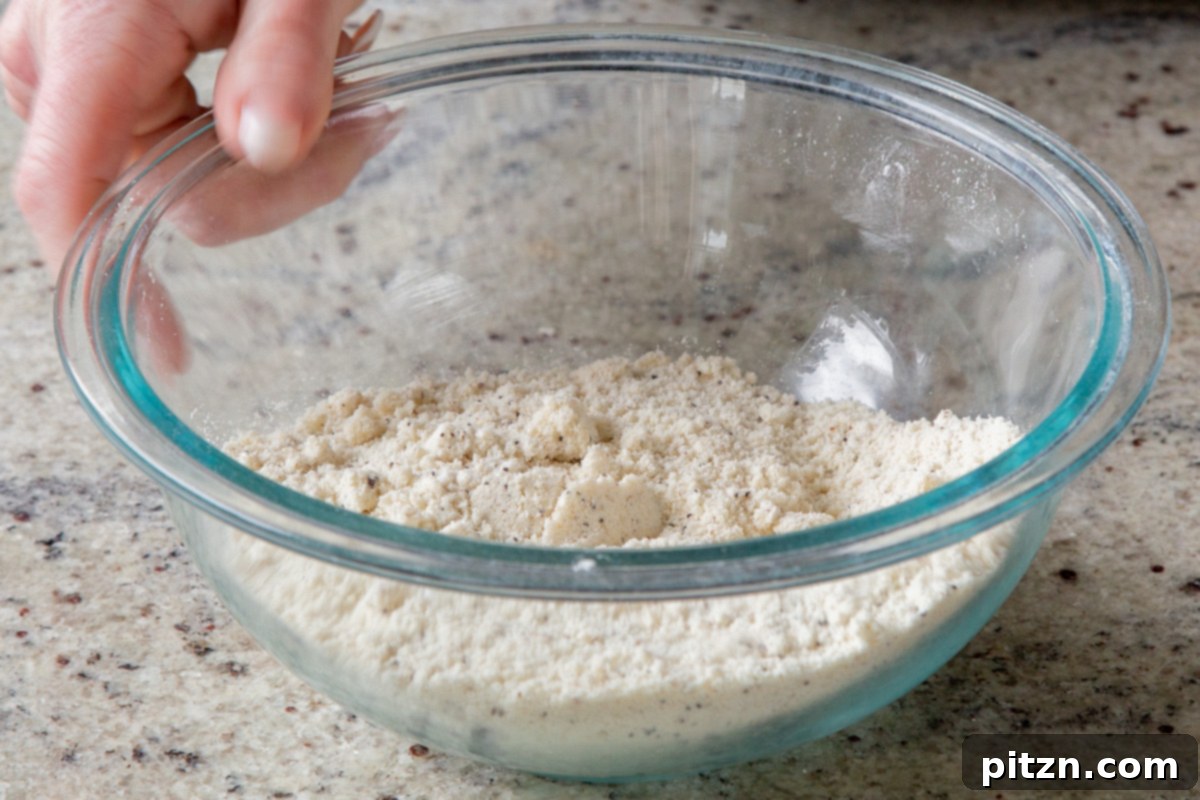 A close-up view of the perfectly mixed dry ingredients for the vegan lemon cookies, showcasing an even distribution and readiness for the wet components.