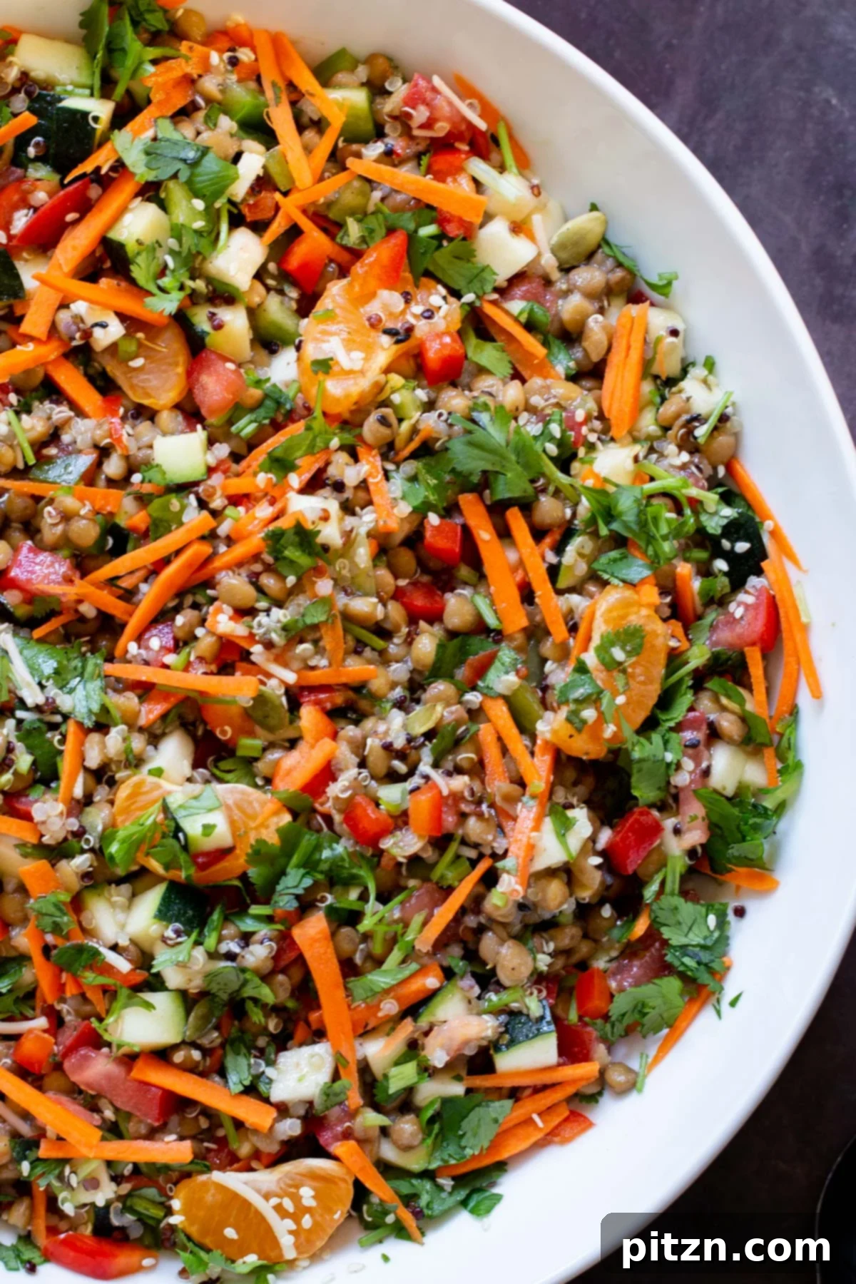 Effortless Lentil Quinoa Medley 2 Close-up of a vibrant lentil quinoa salad with colorful vegetables and dressing in a white bowl, ready to be enjoyed.