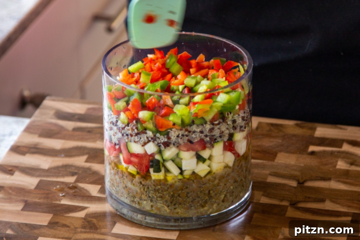 Effortless Lentil Quinoa Medley 17 Colorful chopped bell peppers being layered into the glass jar, adding crispness and a visual pop to the salad.