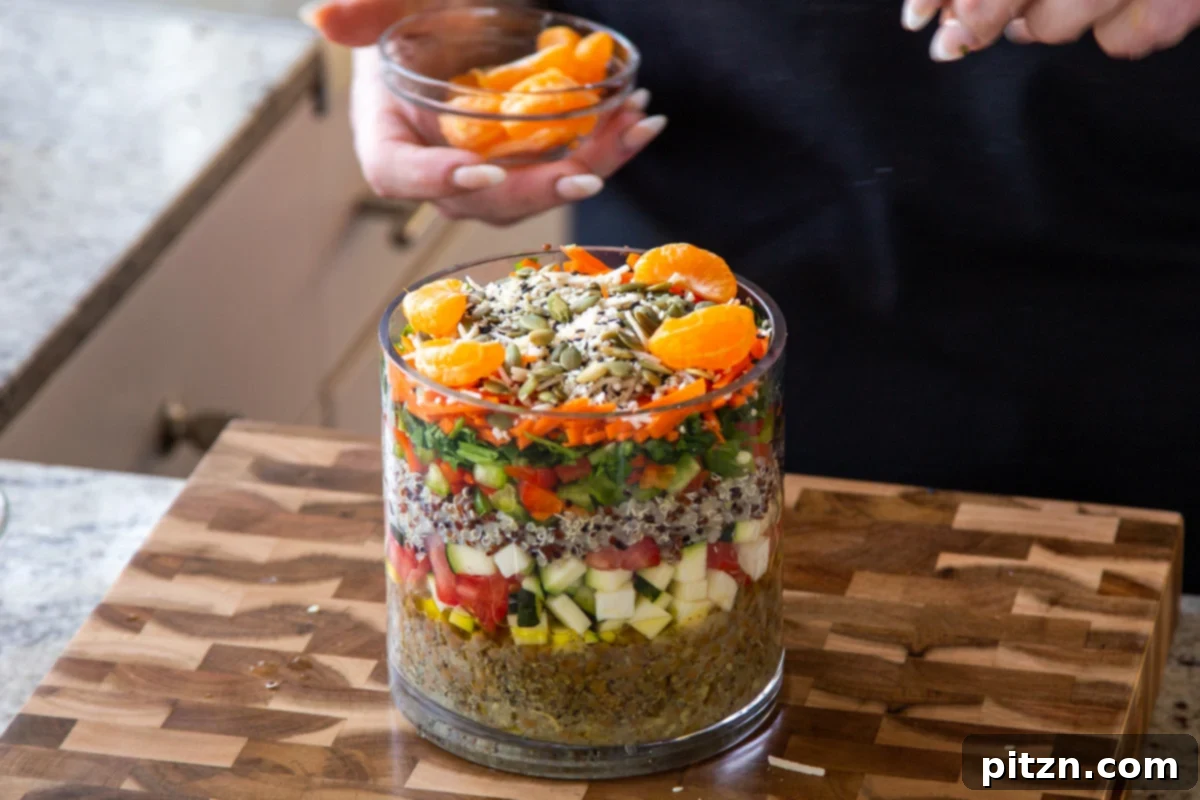 Effortless Lentil Quinoa Medley 21 Sweet orange segments placed on top of the salad layers in the glass jar, adding a burst of citrus and color.