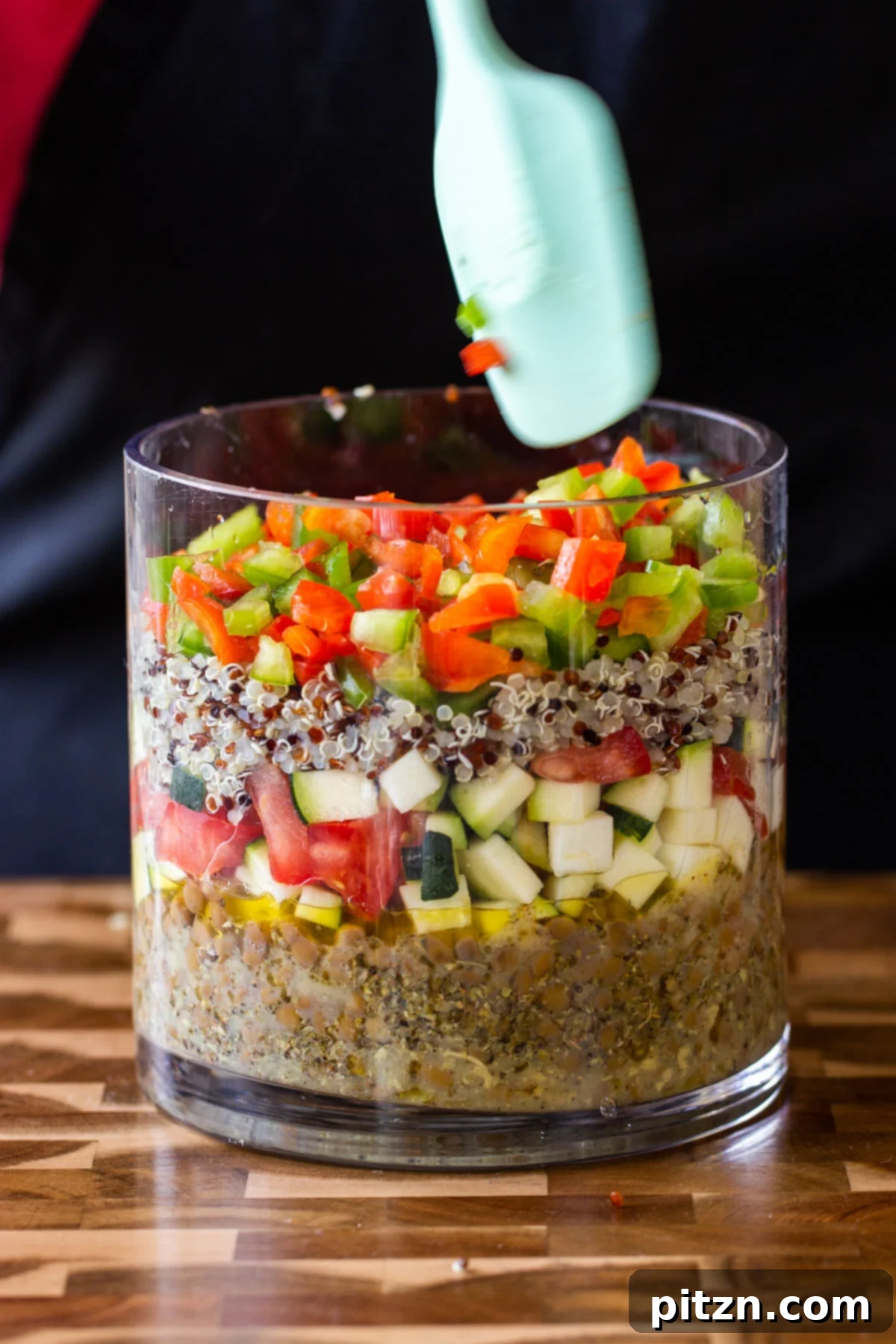 Effortless Lentil Quinoa Medley 7 Chopped bell peppers forming a vibrant layer within the glass jar salad, adding color and crunch.