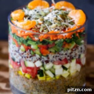 Preparing a layered lentil quinoa salad, with fresh orange slices and seeds being added as a top layer for crunch and sweetness.