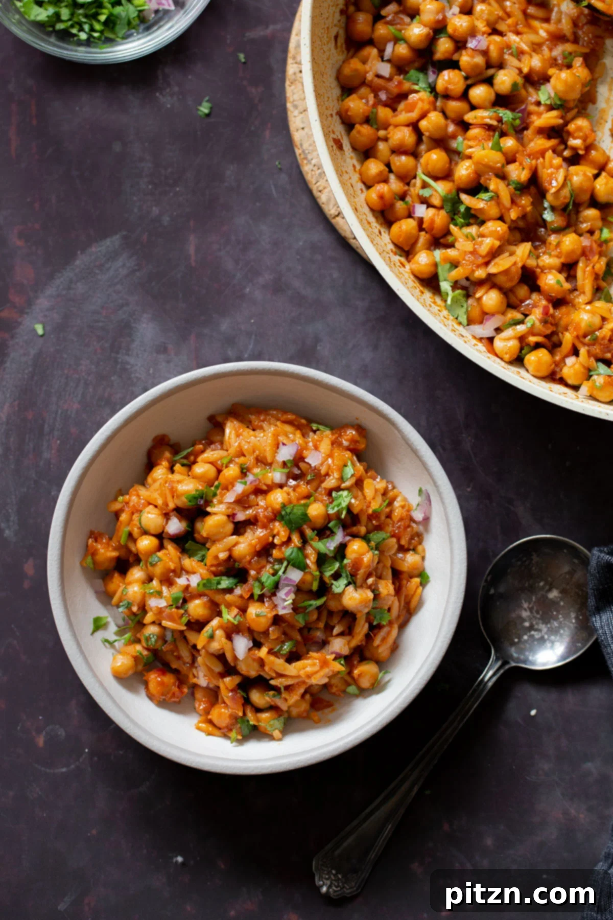 bowl of vegan cajun orzo next to the pan