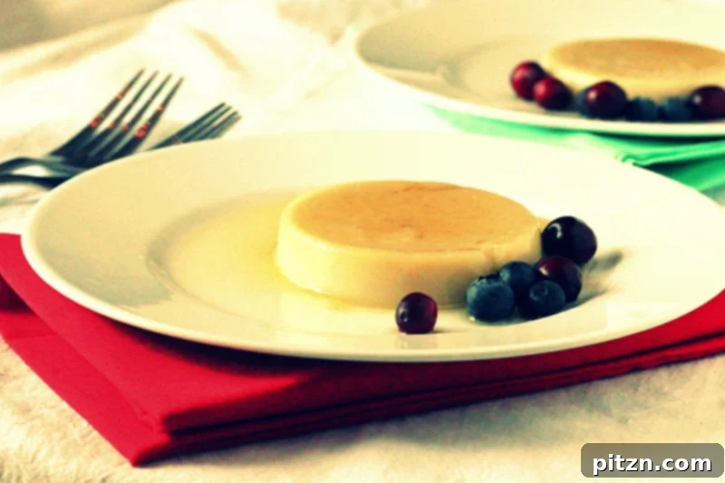 A beautifully presented vegan caramel flan, garnished with fresh cranberries, on a white plate.