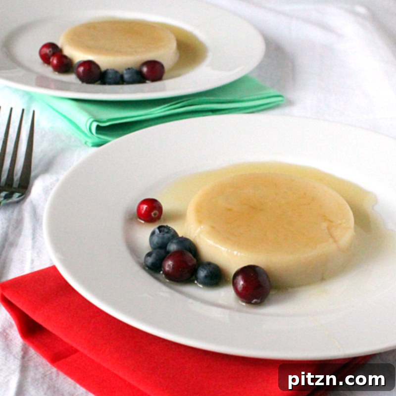 Two servings of vegan caramel flan, one garnished with berries, on a white plate.