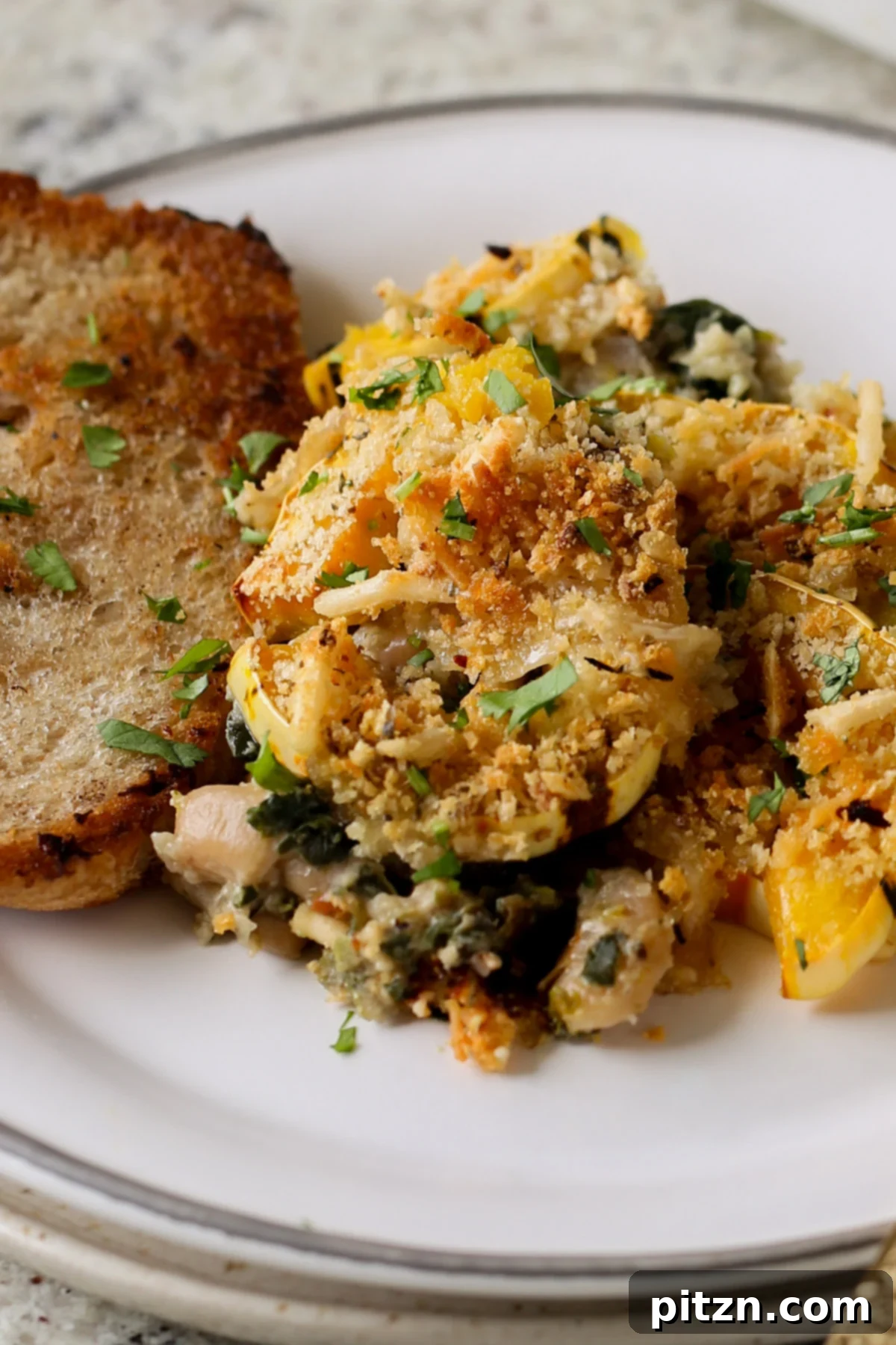 Comforting Delicata Squash and White Bean Casserole 5 delicata squash casserole on a plate with toast