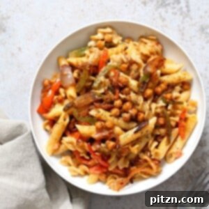 Creamy vegan fajita pasta with chickpeas and colorful vegetables, highlighting its hearty and flavorful appeal.