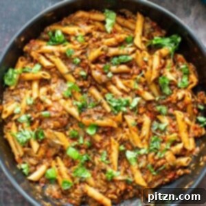 A skillet of one-pan veggie pasta featuring sun-dried tomatoes and mushrooms, illustrating its simplicity and rich ingredients.