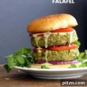 An easy vegan falafel burger, featuring a crispy chickpea patty with tahini dressing and hummus.