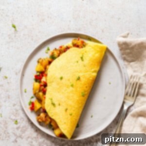 A perfectly cooked vegan omelet served with a side of crispy breakfast potatoes, highlighting a wholesome plant-based breakfast.