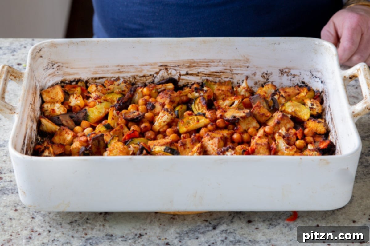 Freshly baked Gochujang tofu and vegetables on the sheet pan, drizzled with dressing.
