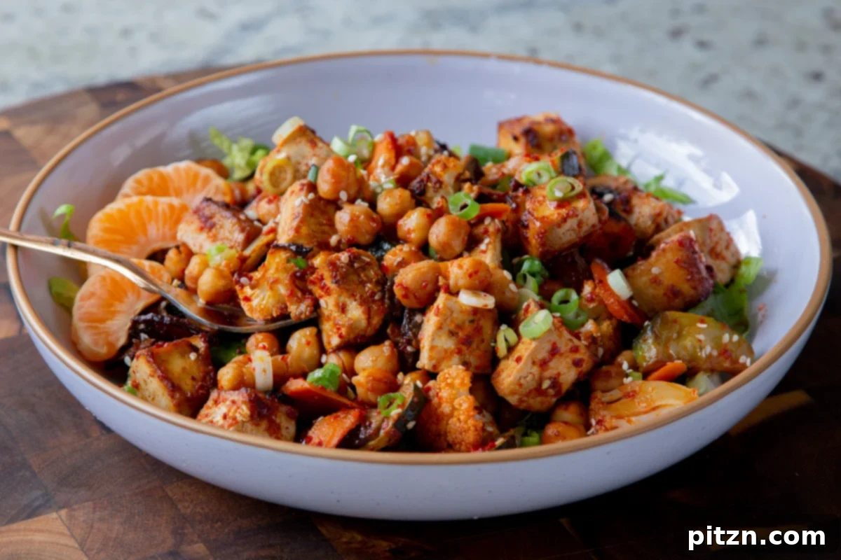 A beautifully assembled Gochujang tofu and veggie bowl served over lettuce, ready to eat.