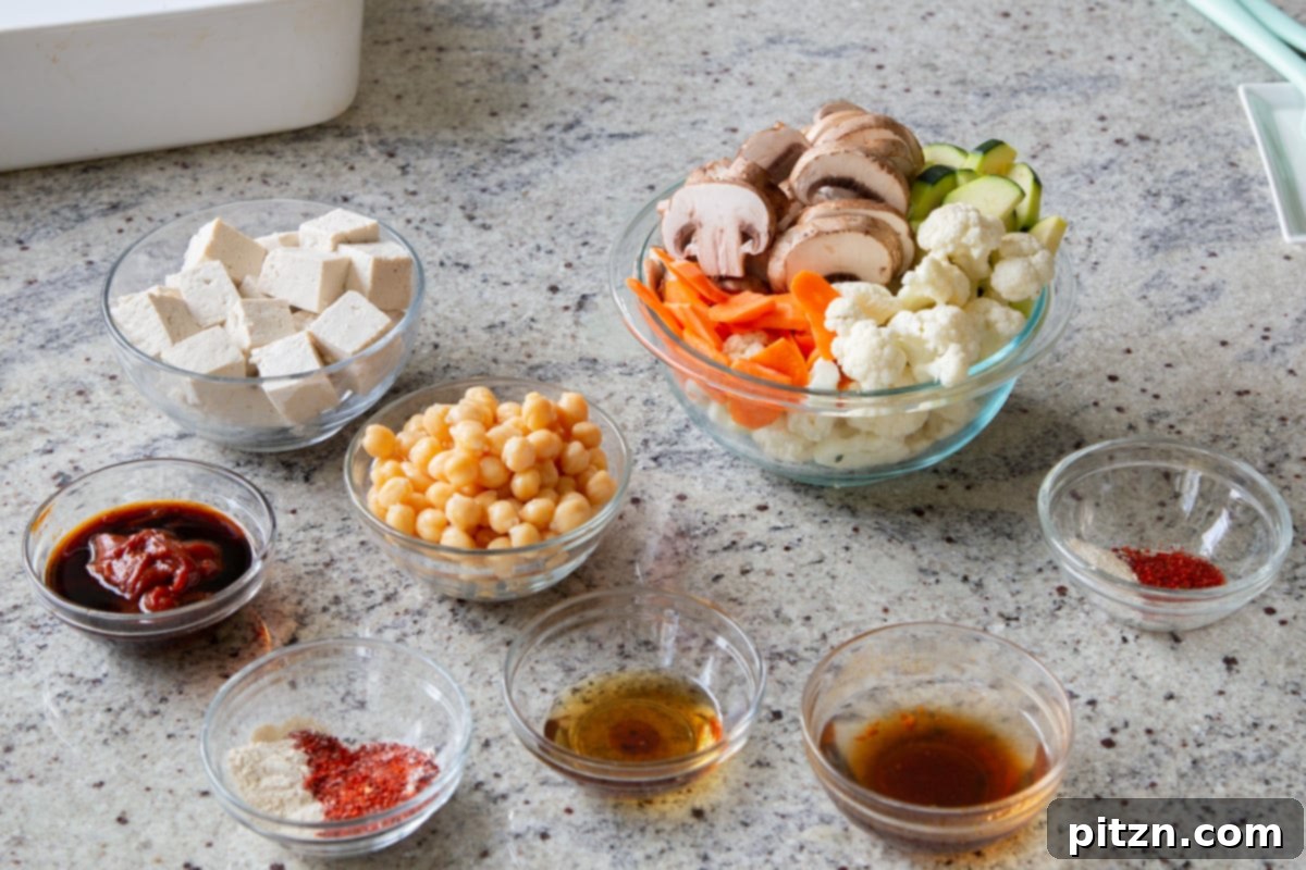 Assortment of fresh ingredients for Gochujang bowls, including tofu, Gochujang paste, and vegetables, laid out on a kitchen counter.