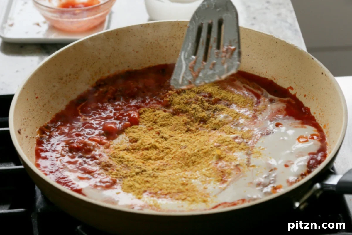 Effortless Rosé Beans for All 9 Adding nutritional yeast to the simmering tomato and non-dairy cream sauce in the pan.
