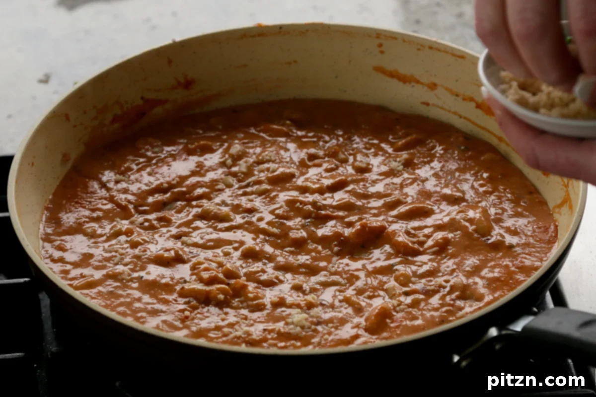 Effortless Rosé Beans for All 13 The quick rosé sauce with white beans in the pan after simmering, perfectly thickened and ready.