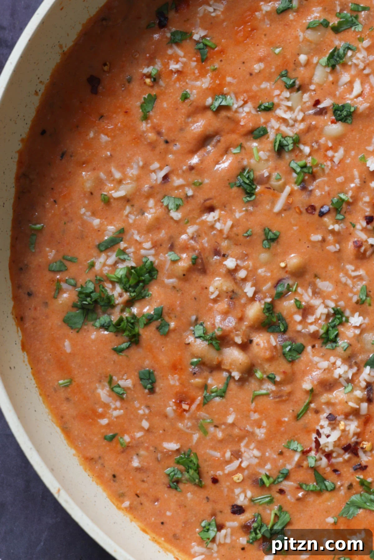 Effortless Rosé Beans for All 5 Close-up view of the vibrant pink rosé sauce with white beans simmering gently in a single pan.