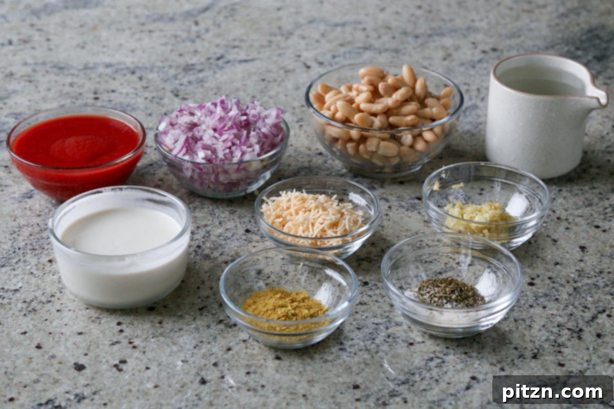 Effortless Rosé Beans for All 6 Assorted ingredients for the easy rosé sauce, including white beans, tomato puree, non-dairy cream, and herbs, arranged on a kitchen counter.