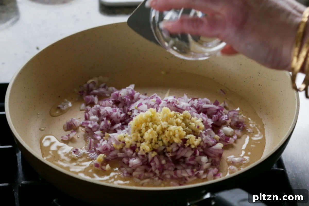 Effortless Rosé Beans for All 7 Adding chopped onion and minced garlic to hot oil in a skillet.