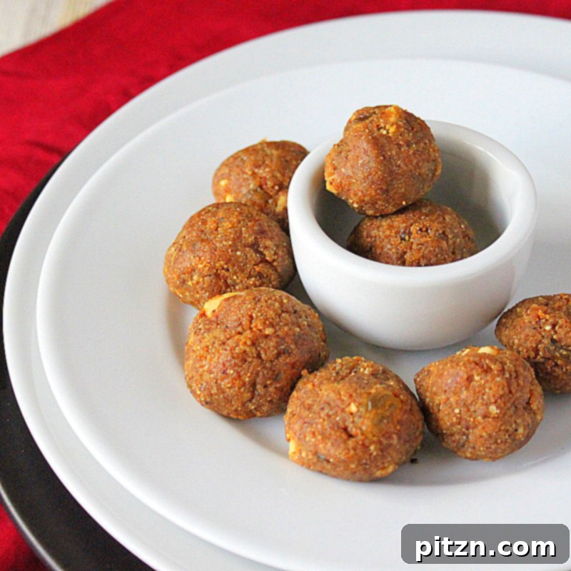 Vegan Indian Besan Laddoo Sweet Chickpea Delight with Cashews and Raisins 4 Beautifully crafted Besan Laddoo in a serving bowl