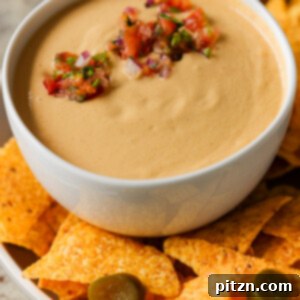 cashew nacho cheese in a serving bowl topped with salsa