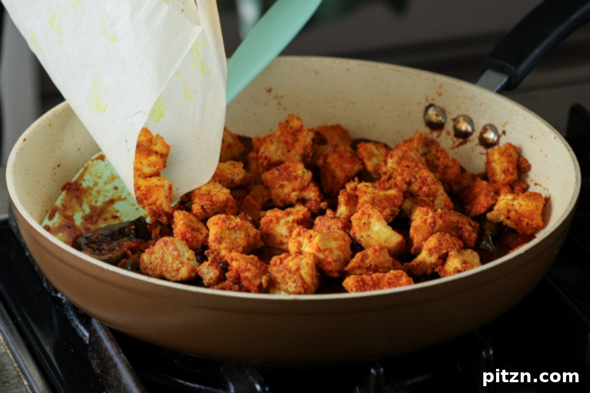 Tofu Kondattam: Crispy & Spicy South Indian Tofu 22 Adding crispy baked tofu pieces to the prepared Kondattam sauce in the skillet