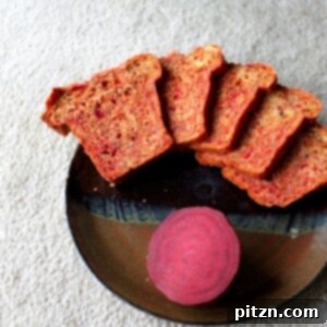 Slices of beet and blueberry mini loaf arranged on a plate with a slice of beet
