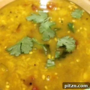 A close up of teen daal tadka garnished with cilantro