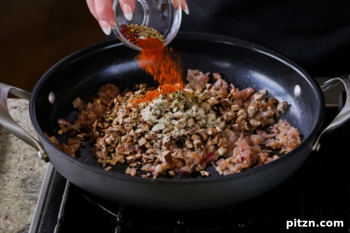 Weeknight Skillet Sausage and White Bean Pasta 11 Adding the remaining spices, including smoked paprika and onion powder, along with concentrated tomato paste, to the mushroom and walnut mixture.