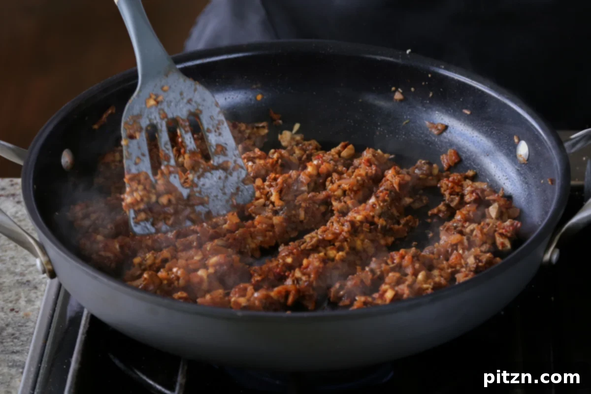 Weeknight Skillet Sausage and White Bean Pasta 14 The cooked vegan sausage crumble, a rich blend of mushrooms and walnuts, sizzling gently in the skillet after sautéing.
