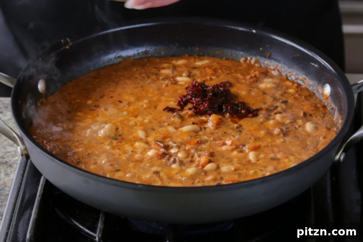 Weeknight Skillet Sausage and White Bean Pasta 19 Adding finely chopped sun-dried tomatoes to the simmering vegan sausage pasta sauce, infusing it with concentrated sweet and savory flavors.