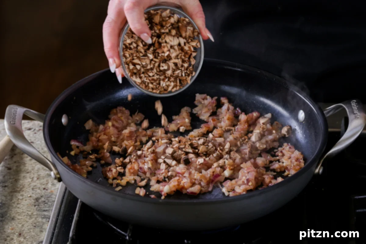 Weeknight Skillet Sausage and White Bean Pasta 9 Adding chopped mushrooms to the sautéed onion and garlic in the skillet to start building the texture of the vegan sausage.