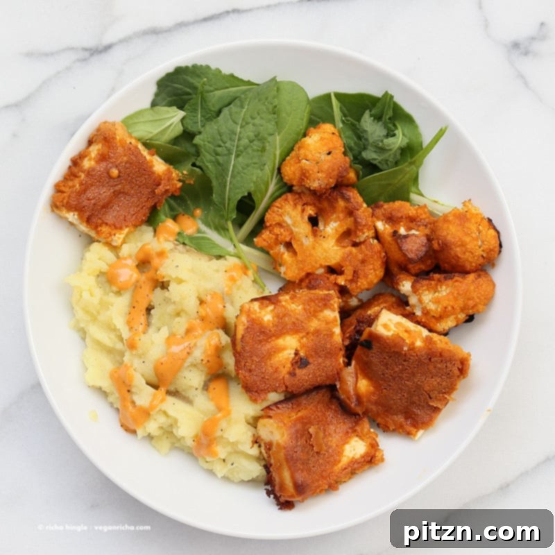 A vibrant close-up of the Peanut Butter Tofu Bowl, showcasing the golden tofu, creamy mashed potatoes, and fresh greens, ready to be enjoyed.