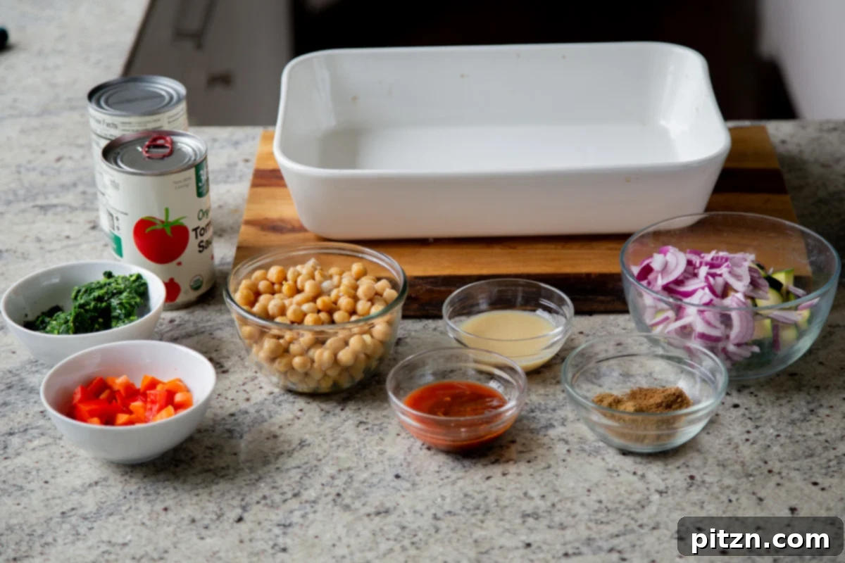 Spicy Golden Baked Zucchini Chickpea Curry Allergen Free 7 Assortment of fresh ingredients for zucchini chickpea curry laid out on a kitchen counter, including zucchini, chickpeas, spices, and sauces.