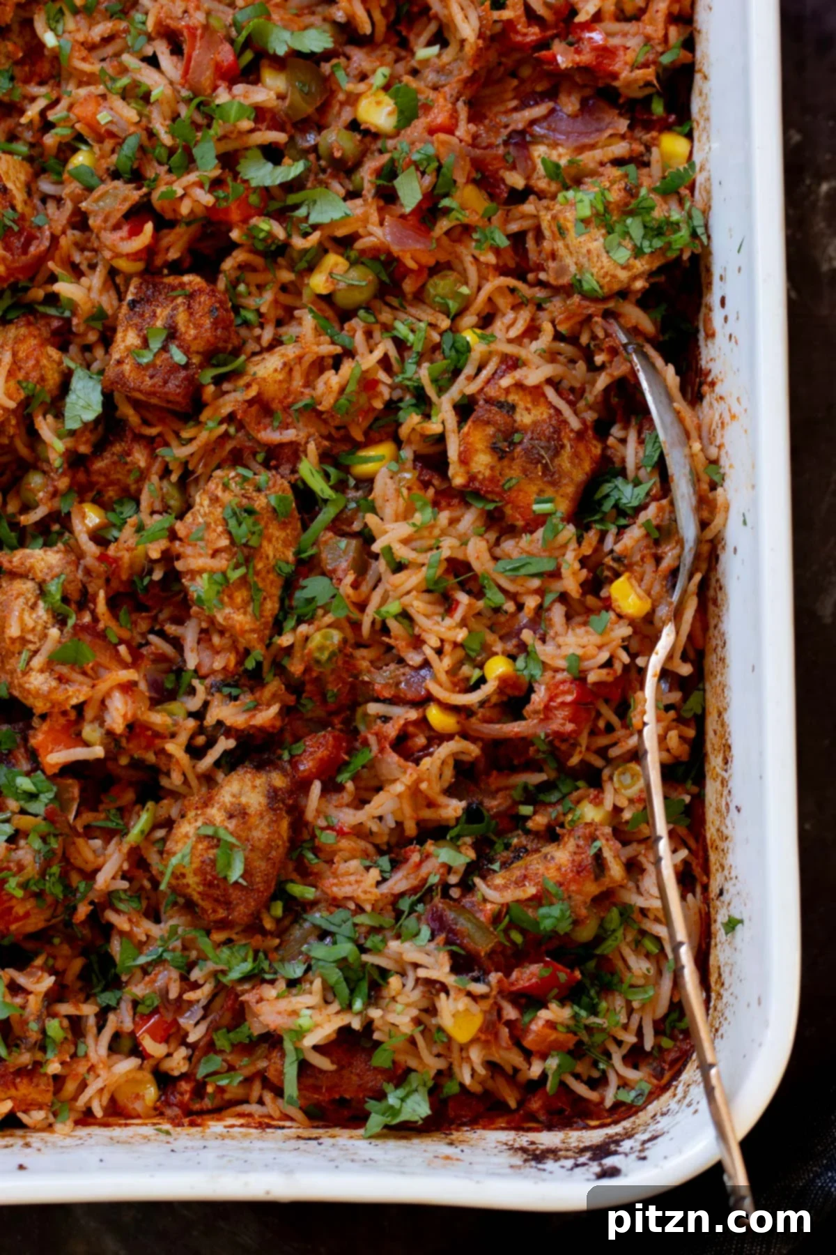 Fragrant Tikka Masala Rice Bake with Golden Crispy Tofu 4 Close-up view of the baked Tikka Masala Rice in the pan, showing fluffy grains and seasoned tofu, ready to be served.