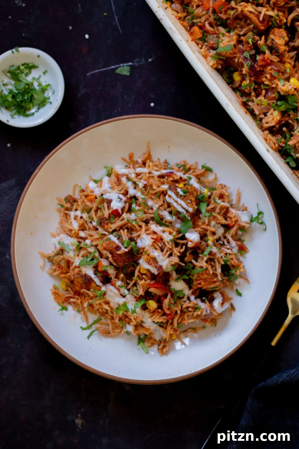 Fragrant Tikka Masala Rice Bake with Golden Crispy Tofu 5 A delicious serving of Tikka Masala Rice Bake, garnished with fresh cilantro and a dollop of non-dairy yogurt, showcasing its appetizing appeal.