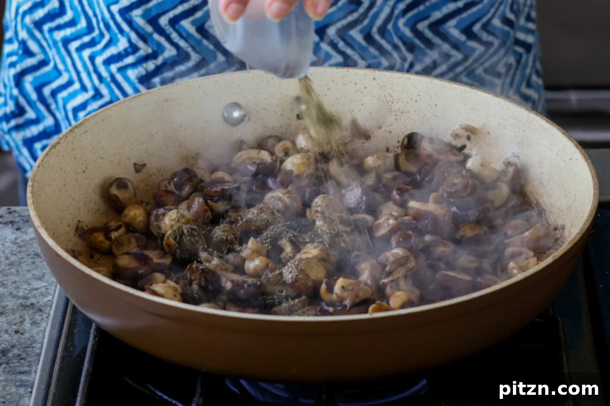 Sprinkling dried thyme over the sautéing mushrooms, infusing aromatic herbs into the filling.