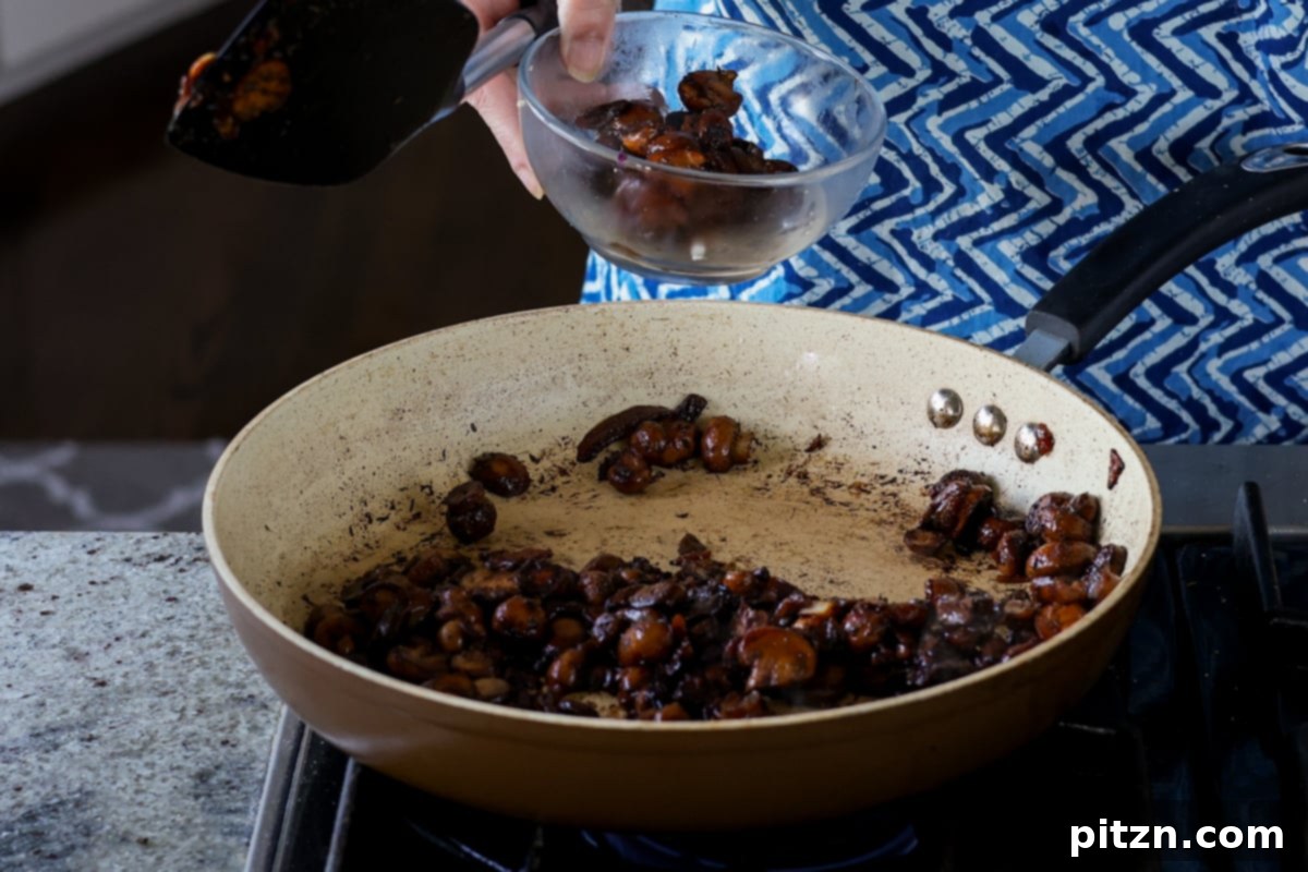 A portion of sautéed mushrooms reserved in a bowl, to be used as a topping later for textural contrast in the puffs.